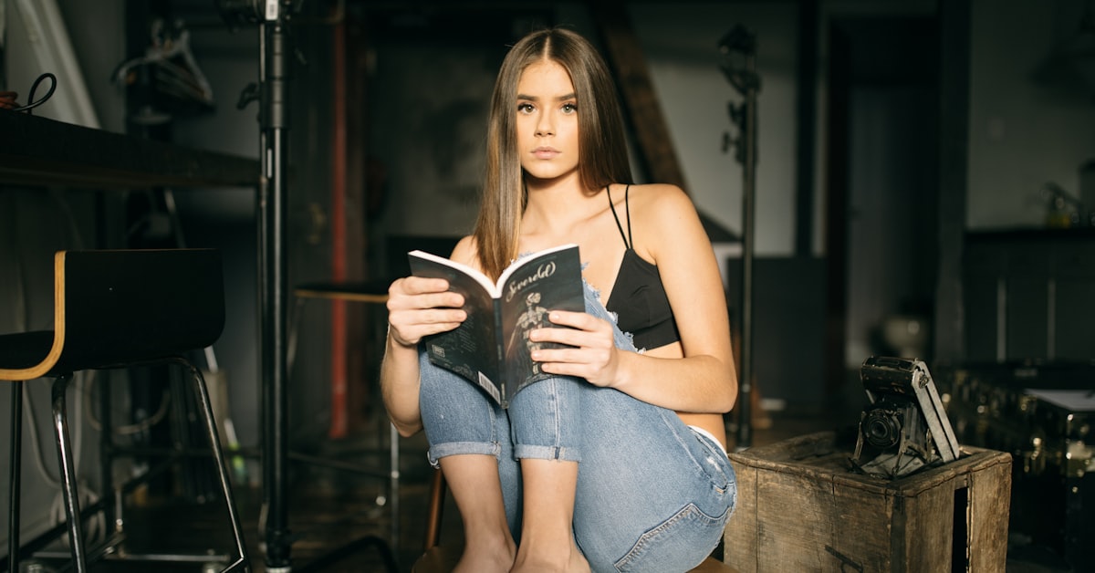 Frau liest entspannt ein Buch als Einschlafritual bei Liebeskummer