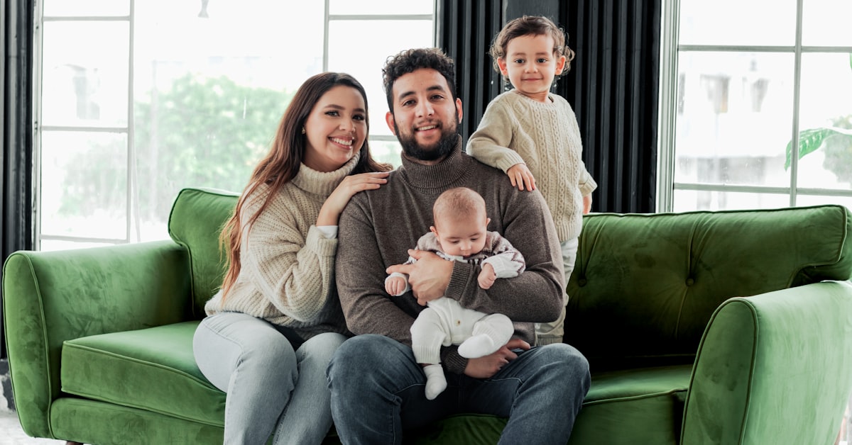 Familie sitzt zusammen auf dem Sofa und gibt Halt bei Liebeskummer