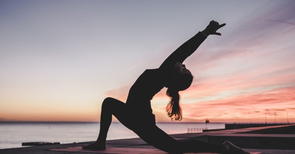 Frau in Yogahaltung im Freien als Symbol für Yoga gegen Liebeskummer